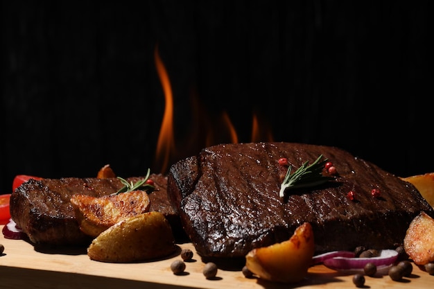 Conceito de comida saborosa com bifes em fundo escuro