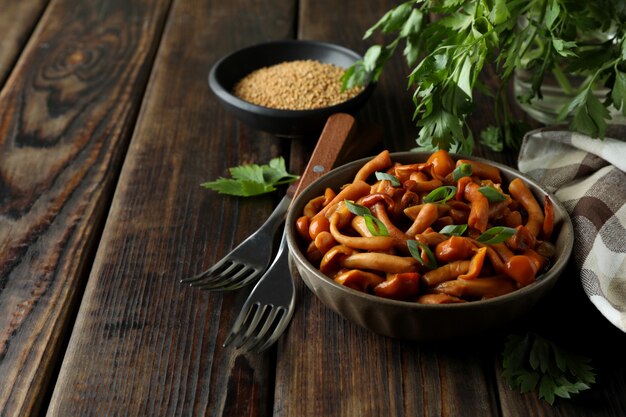 Conceito de comida saborosa com cogumelos marinados na mesa de madeira