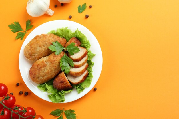 Conceito de comida saborosa com costeletas em fundo laranja