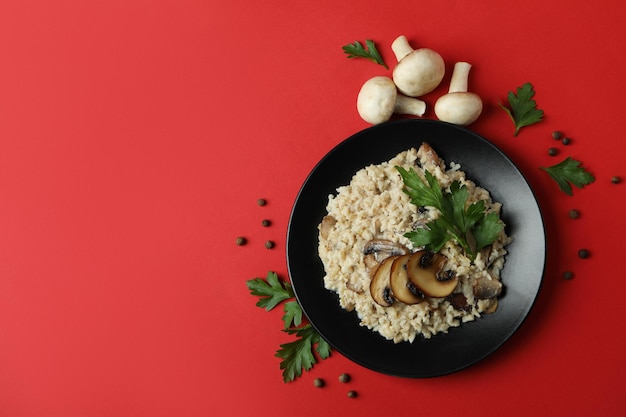 Conceito de comida saborosa com risoto com cogumelos em fundo vermelho