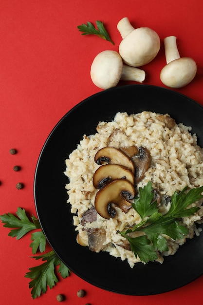 Conceito de comida saborosa com risoto com cogumelos em fundo vermelho