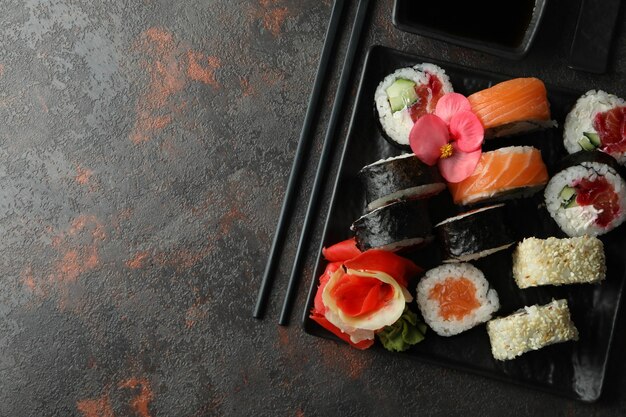 Conceito de comida saborosa com rolos de sushi em plano de fundo texturizado escuro