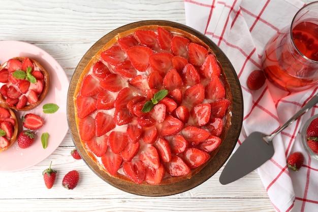 Conceito de comida saborosa com torta de morango em fundo branco de madeira.