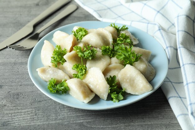 Conceito de comida saborosa com vareniki ou pierogi na mesa texturizada cinza