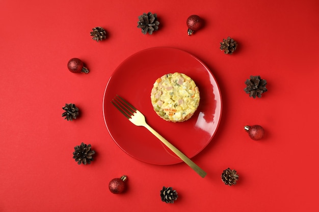 Conceito de comida saborosa de natal com salada olivier em fundo vermelho