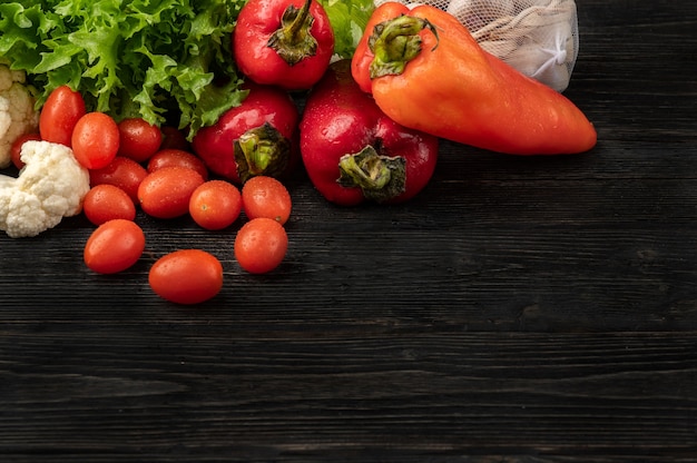 Conceito de comida saudável com vegetais em um fundo escuro de madeira com vista superior e espaço de cópia