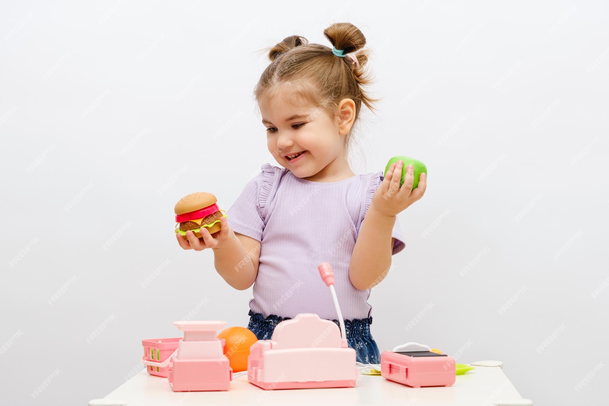 Legumes de brinquedo na cesta, caixa registradora com moedas, loja de jogos  infantis, conceito de compra de comida online, closeup