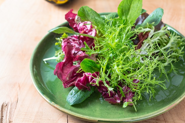 Conceito de comida saudável Mix de salada de legumes em chapa verde em fundo de madeira