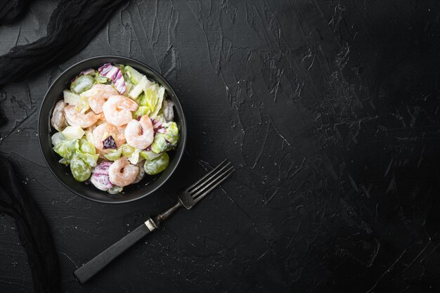 Conceito de comida saudável, prato de salada de dieta. Salada de frutos do mar frescos com conjunto de camarão ou camarão, com molho de maçã e uva, em mesa de pedra preta, vista superior plana