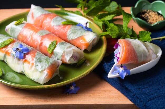 Conceito de comida saudável rolinhos primavera de papel de arroz de salmão defumado fresco com vegetais coloridos com espaço de cópia