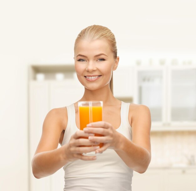 conceito de comida, saúde e dieta - jovem sorridente segurando um copo de suco de laranja