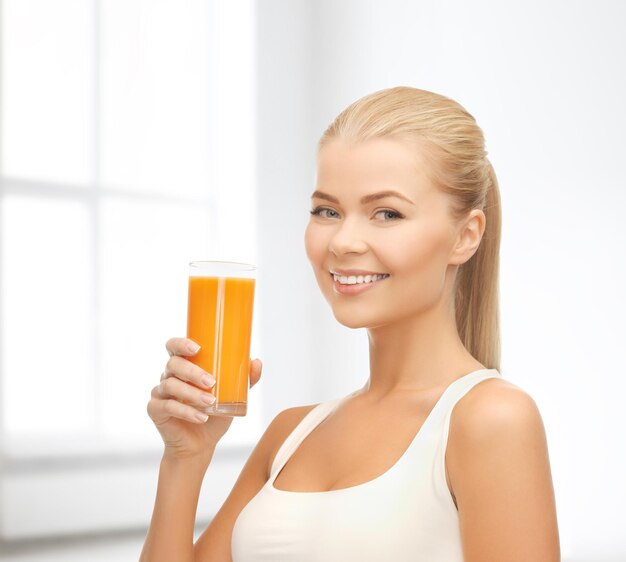 conceito de comida, saúde e dieta - jovem sorridente segurando um copo de suco de laranja