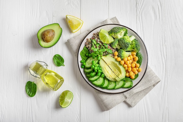 Conceito de comida vegetariana saudável: quinua com legumes, sementes e ervas em fundo branco. Vista do topo.