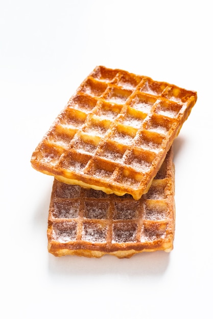 Conceito de comida Waffles quadrados clássicos com sugat de confeiteiro em cima no fundo branco