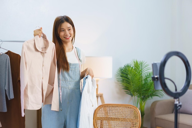 Conceito de compras online jovens mulheres asiáticas estão vendendo e apresentam detalhes da camisa em streaming de vídeo