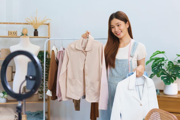 Conceito de compras online Jovens mulheres asiáticas estão vendendo e apresentam detalhes da camisa em streaming de vídeo