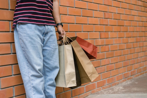 Conceito de compras uma pessoa de jeans azul claro e sapatos brancos encostados na parede