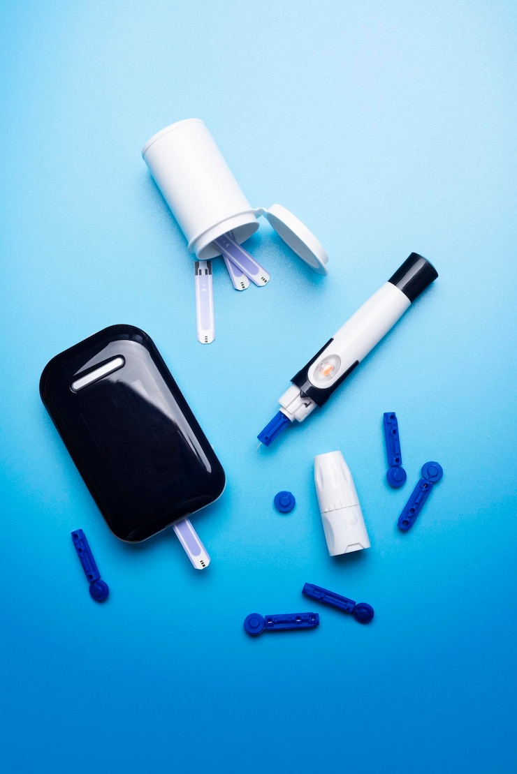 Foto conceito de conscientização sobre a diabetes de tiras de teste e lancetas de medidor de glicose em fundo azul