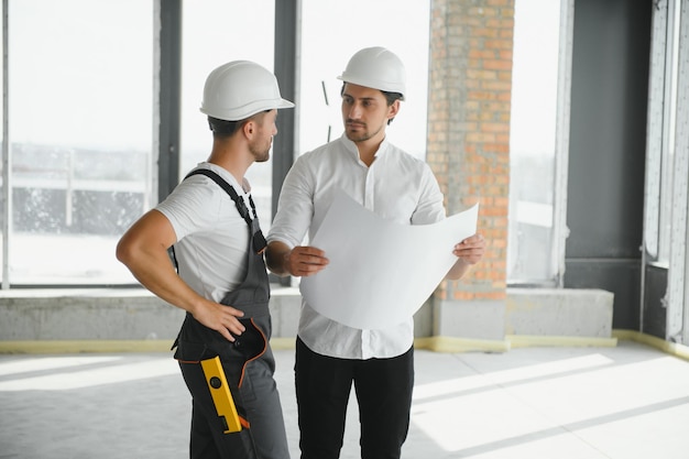 Conceito de construção de engenheiro e arquiteto, trabalhando no canteiro de obras com impressão azul