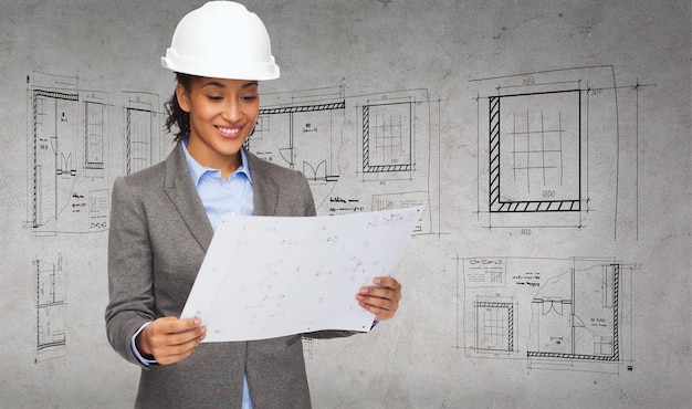 Foto conceito de construção, desenvolvimento, construção e arquitetura - empresária sorridente no capacete branco, olhando para a planta