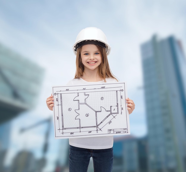 conceito de construção, desenvolvimento, construção e arquitetura - menina sorridente no capacete branco mostrando a planta