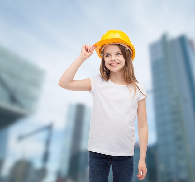 conceito de construção e pessoas - menina sorridente no capacete protetor olhando para cima