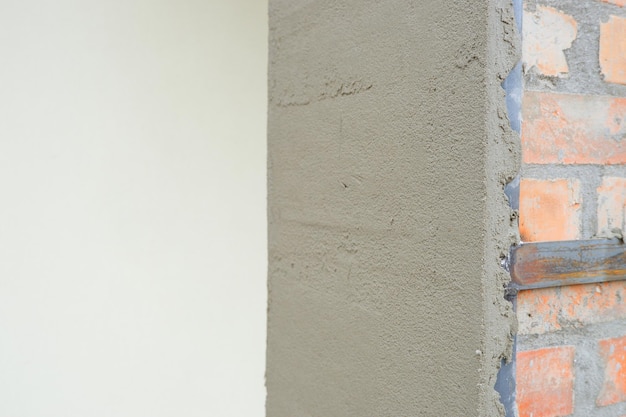 conceito de construção gesso de cimento O processo de gesso de uma coluna de tijolos Gesso da parede