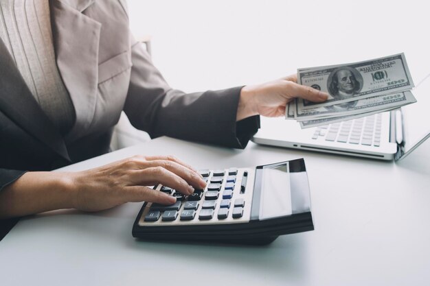 Conceito de contabilidade empresarial Homem de negócios usando calculadora com orçamento de computador portátil e papel de empréstimo no escritório