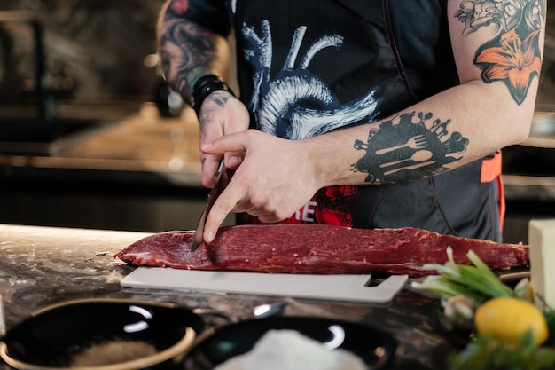 Conceito de cozimento correto de carne por cozinheiro tatuado