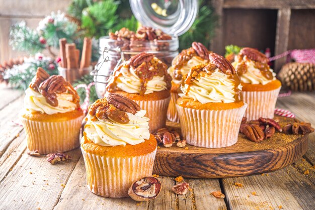 Conceito de cozimento de inverno outono, cupcakes doces salgados de pecan pie. fundo de madeira com decoração de natal e ação de graças