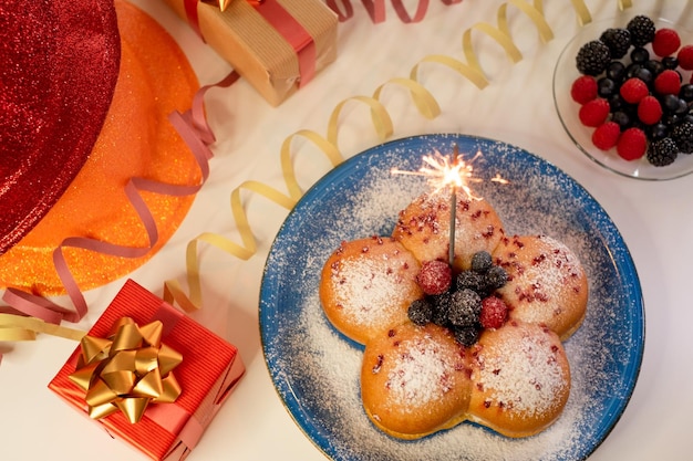 Conceito de cozinha caseira Pão de leite doce caseiro orgânico fresco cheio de creme e decorado com bagas Feriado com luz cintilante e presentes