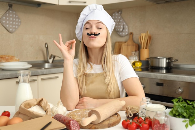 Conceito de cozinhar com jovem atraente na sala da cozinha