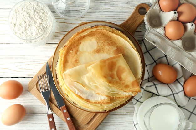 Conceito de cozinhar crepes na mesa de madeira branca