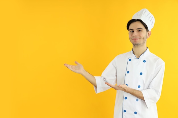 Conceito de cozinhar jovem chef em fundo amarelo