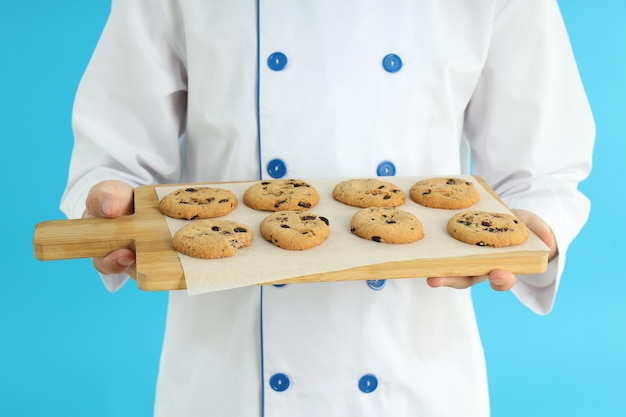 Foto conceito de cozinhar jovem chef masculino com tábua de biscoitos