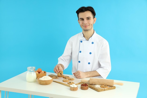 Conceito de cozinhar jovem chef masculino em fundo azul