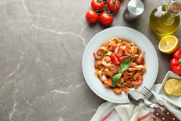 Conceito de cozinhar macarrão de camarão em mesa texturizada cinza