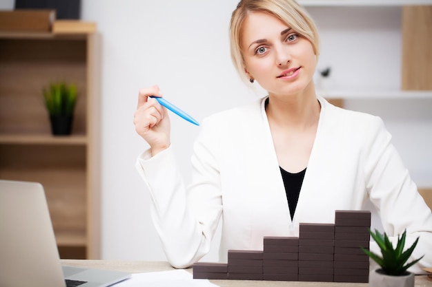 Conceito de crescimento de negócios, bela jovem empresária constrói planos de desenvolvimento da empresa.