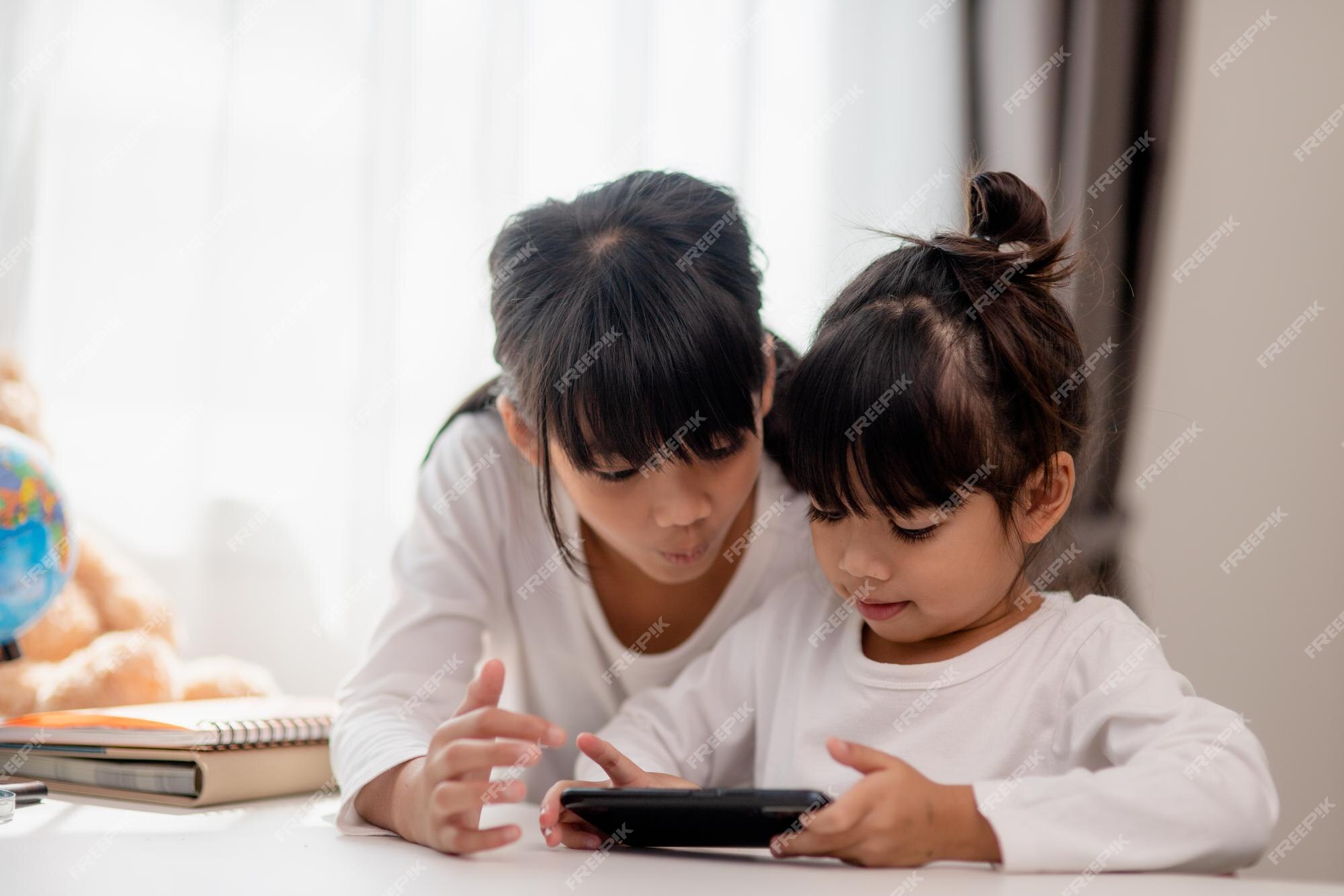 Crianças Conceito E Gadgets. Duas Meninas Irmãs Irmãos Olhar Para