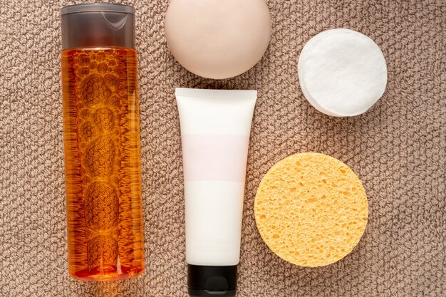 Conceito de cuidado de rosto. creme, sabonete, esponja, algodão e pastilha na toalha.