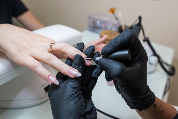 Conceito de cuidados com as unhas Manicure faz manicure para uma cliente em um salão de beleza