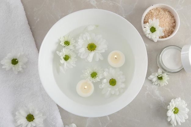 Conceito de cuidados para as mãos com cosméticos em plano de fundo texturizado cinza