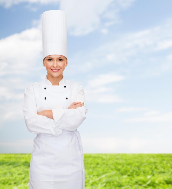 conceito de culinária e comida - chef feminino sorridente com braços cruzados
