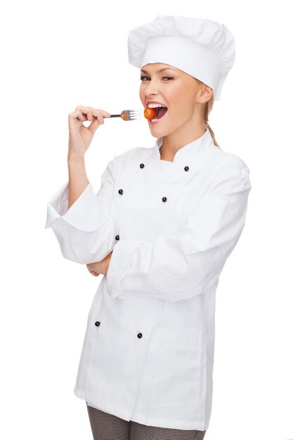 conceito de culinária e comida - chef feminino sorridente, cozinheiro ou padeiro com garfo e tomate