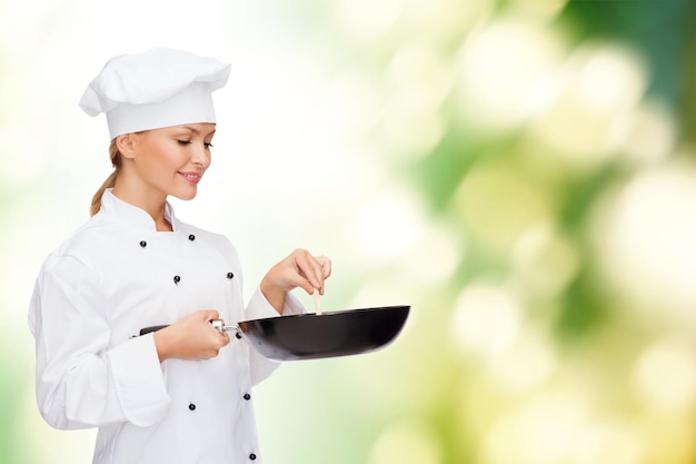 conceito de culinária e comida - chef feminino sorridente, cozinheiro ou padeiro com panela e colher