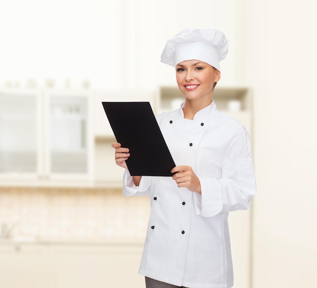 conceito de culinária, propaganda e comida - chef, cozinheiro ou padeiro feminino sorridente com papel de menu preto em branco