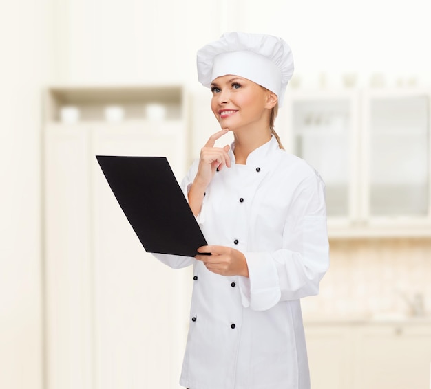 conceito de culinária, propaganda e comida - chef, cozinheiro ou padeiro feminino sorridente com papel de menu preto em branco