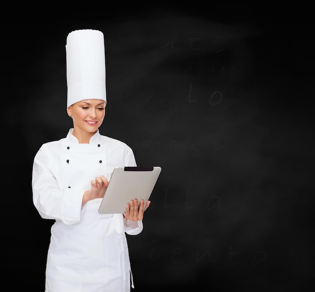 conceito de culinária, tecnologia e comida - chef feminino sorridente com computador tablet pc