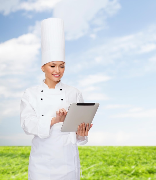 conceito de culinária, tecnologia e comida - chef feminino sorridente com computador tablet pc