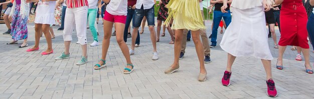 Conceito de dança e flashmob social - diversão e dança com no verão em uma rua da cidade. Close-up dos pés dos dançarinos.